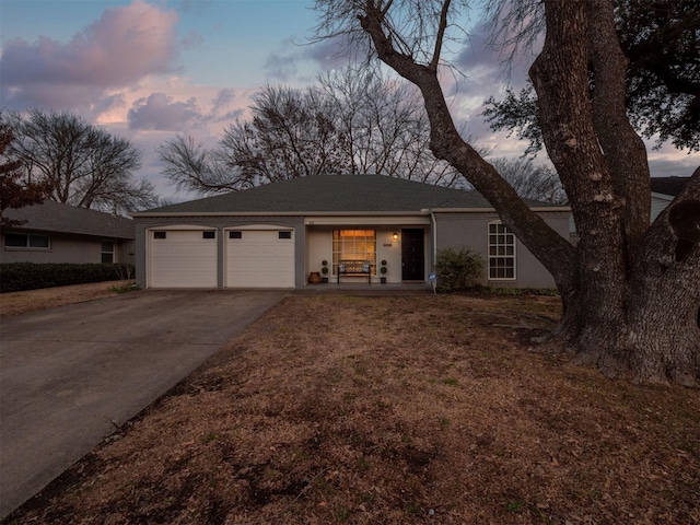 ranch-style home with an attached garage, concrete driveway, and stucco siding