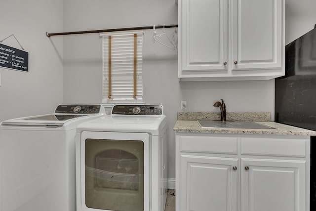 washroom featuring washer and clothes dryer, a sink, and cabinet space