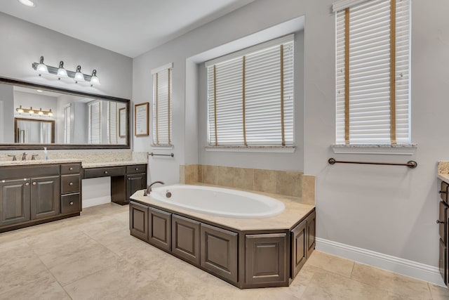 full bath featuring tile patterned floors, a healthy amount of sunlight, vanity, and a garden tub