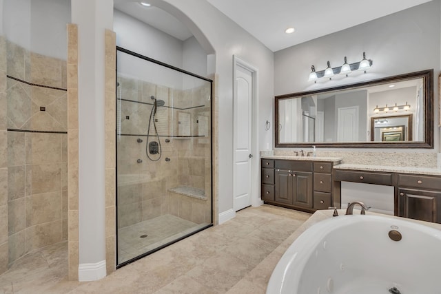 full bath featuring baseboards, a jetted tub, a stall shower, and vanity