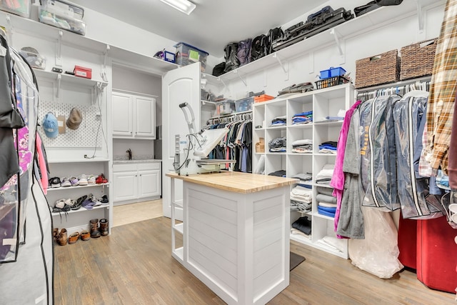 walk in closet featuring a sink and light wood finished floors