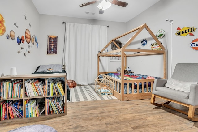 bedroom featuring visible vents, ceiling fan, and wood finished floors