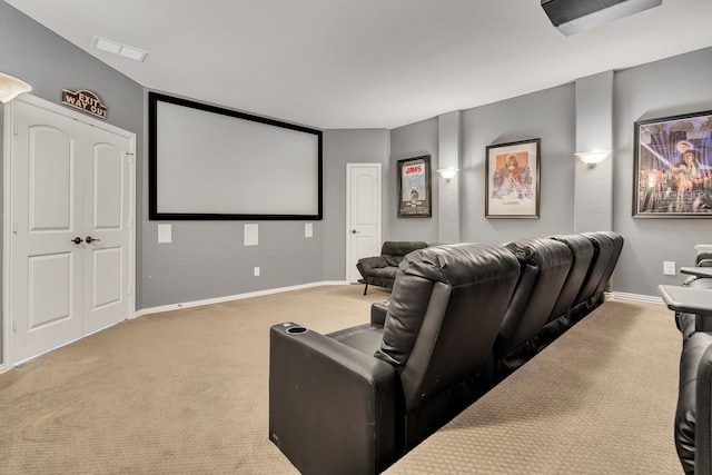 carpeted home theater room featuring visible vents and baseboards