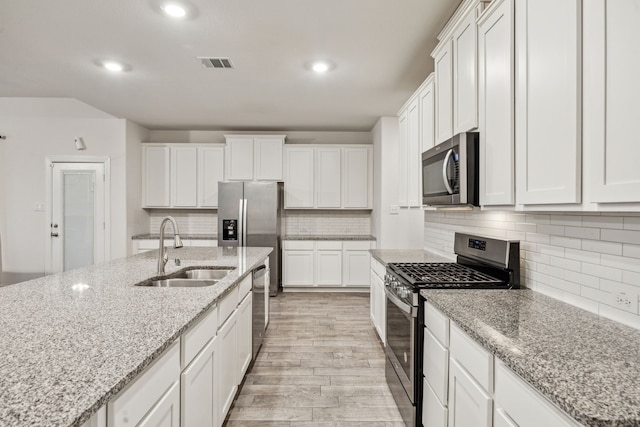 6201 Cheshire St, Celina, TX 76227 - kitchen featuring light stone counters, sink, stainless steel appliances, and white cabinets