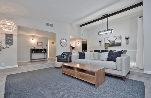 living room featuring wood-type flooring and vaulted ceiling with beams