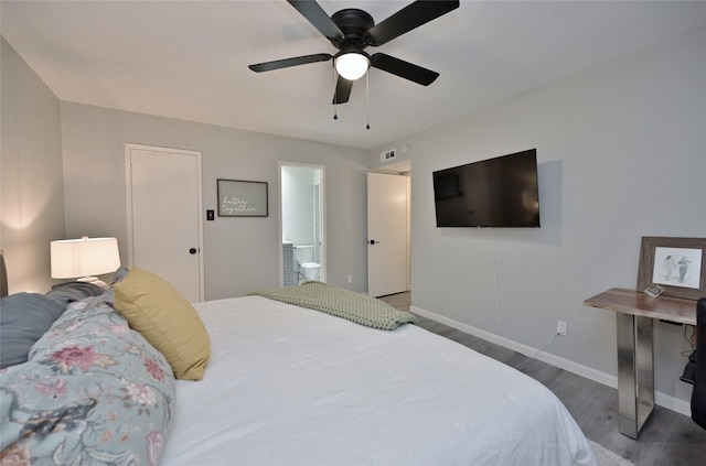 bedroom with connected bathroom, hardwood / wood-style flooring, and ceiling fan