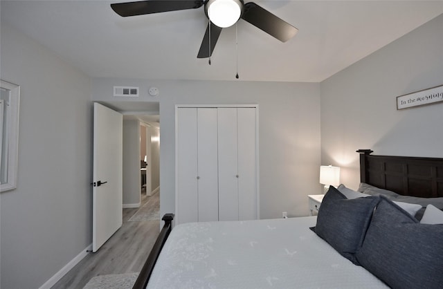 bedroom with ceiling fan, light hardwood / wood-style floors, and a closet