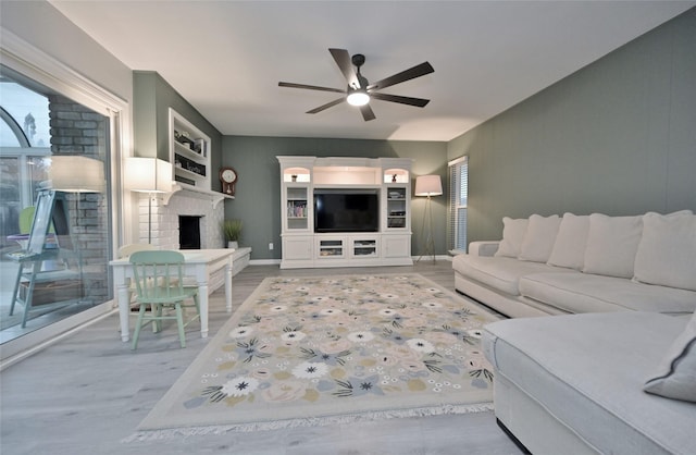living room with hardwood / wood-style flooring, a fireplace, and ceiling fan