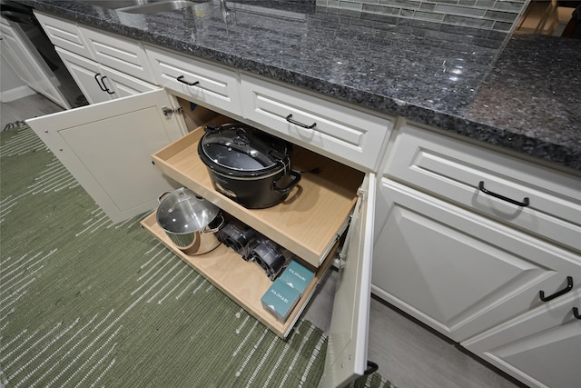 room details featuring dark stone counters and white cabinets
