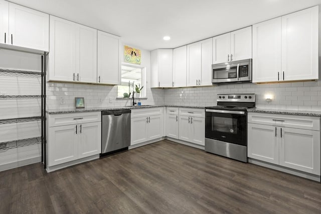 kitchen with white cabinetry, appliances with stainless steel finishes, dark wood-style flooring, and a sink