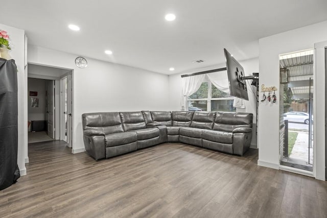 living room featuring baseboards, visible vents, wood finished floors, and recessed lighting