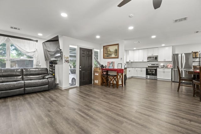 living area with recessed lighting, visible vents, and dark wood finished floors