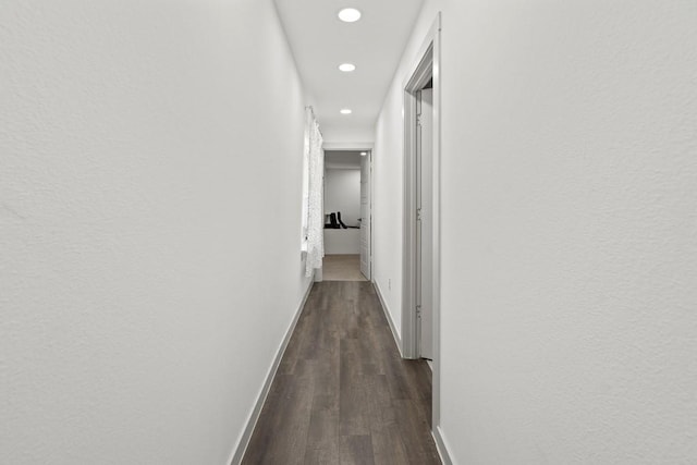 corridor featuring baseboards, dark wood finished floors, and recessed lighting