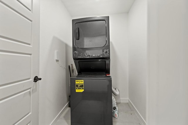 309 Overhill Dr, Arlington, TX 76010 - laundry room with estacked washer and dryer, baseboards, and light tile patterned flooring