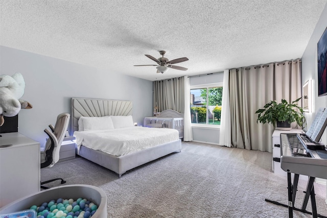 bedroom featuring ceiling fan, carpet, and a textured ceiling