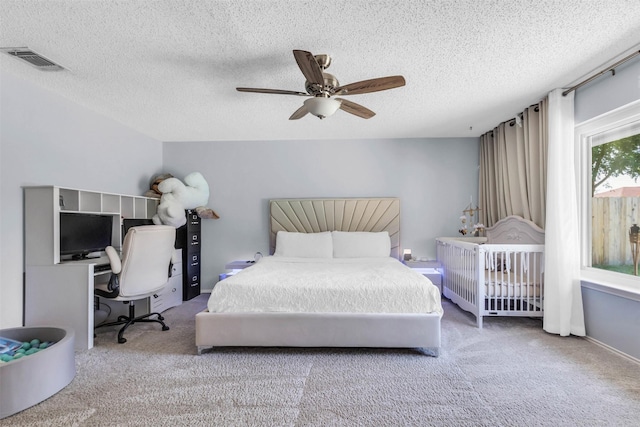 carpeted bedroom with a textured ceiling and ceiling fan