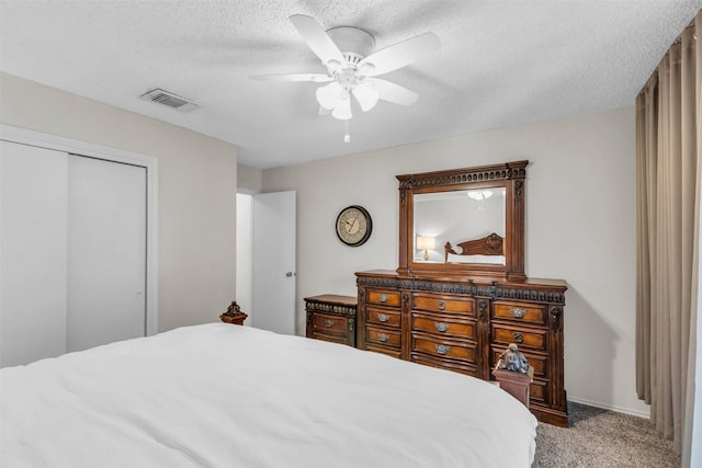 bedroom with ceiling fan, carpet flooring, a textured ceiling, and a closet