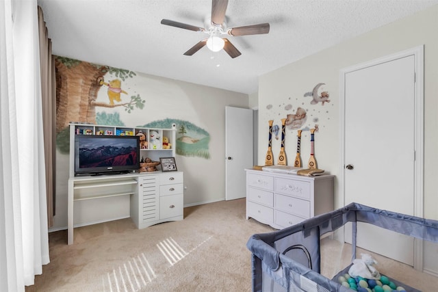 carpeted bedroom with ceiling fan and a textured ceiling