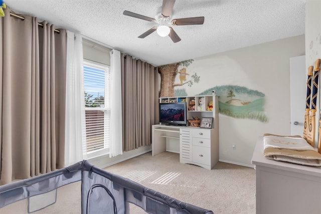 carpeted bedroom with ceiling fan and a textured ceiling
