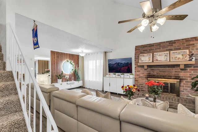 carpeted living room featuring ceiling fan and a fireplace