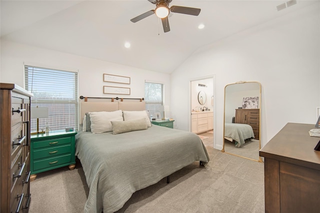 carpeted bedroom featuring vaulted ceiling, connected bathroom, and ceiling fan