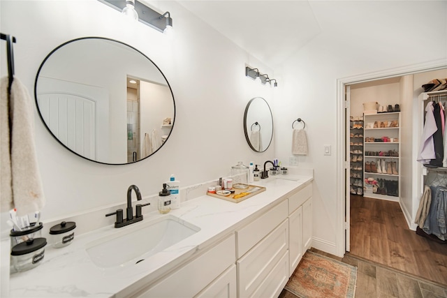 bathroom featuring wood-type flooring, vanity, and walk in shower