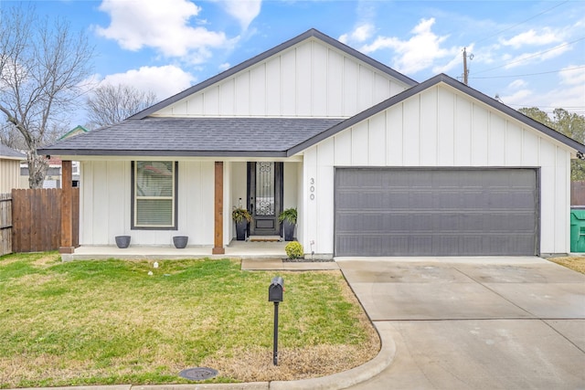 view of front of house with a garage, a front yard, and a porch