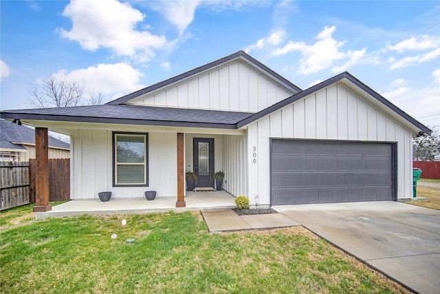 view of front facade featuring a garage, a front yard, and covered porch