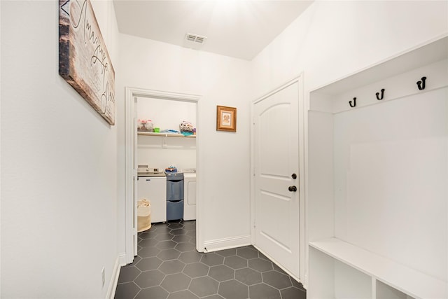 mudroom featuring washer and dryer and dark tile patterned floors