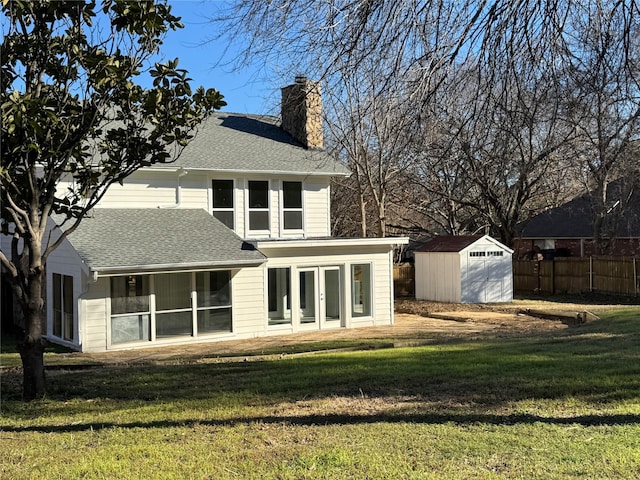 back of house with a storage unit and a lawn