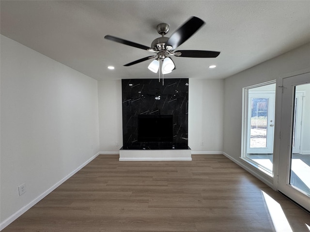 12009 Saddlehorn Ln, Mansfield, TX 76063 - unfurnished living room with wood finished floors, a ceiling fan, recessed lighting, and a fireplace