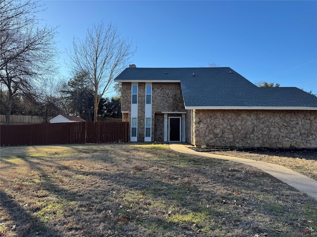 12009 Saddlehorn Ln, Mansfield, TX 76063 - rear view of house featuring stone siding, a chimney, and roof with shingles