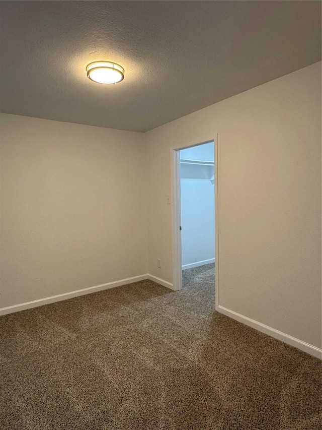 12009 Saddlehorn Ln, Mansfield, TX 76063 - spare room featuring dark carpet and a textured ceiling