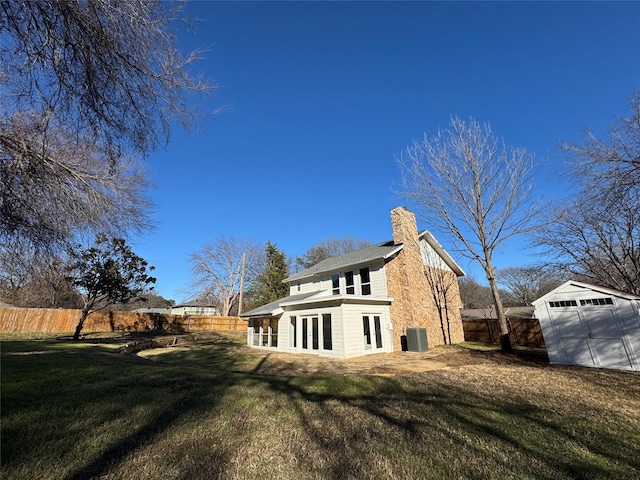 12009 Saddlehorn Ln, Mansfield, TX 76063 - view of home's exterior with french doors, a chimney, a fenced backyard, and a shed