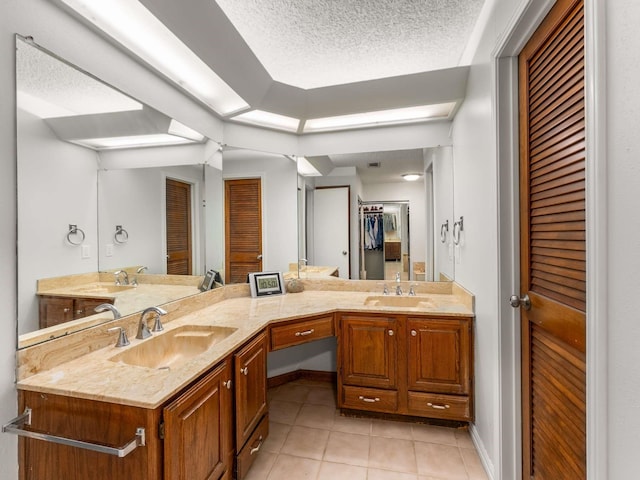 bathroom featuring a textured ceiling, vanity, and tile patterned flooring