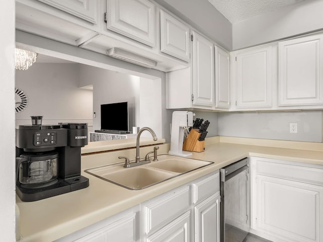 kitchen featuring a textured ceiling, white cabinetry, sink, and stainless steel dishwasher