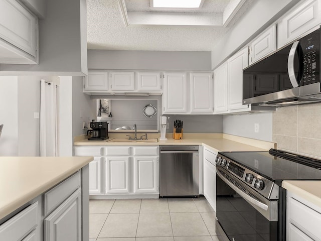 kitchen with sink, a textured ceiling, white cabinets, and stainless steel appliances