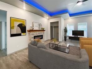 living room with a raised ceiling and light wood-type flooring