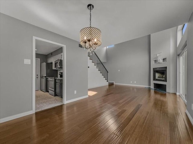 unfurnished living room featuring hardwood / wood-style floors and a notable chandelier