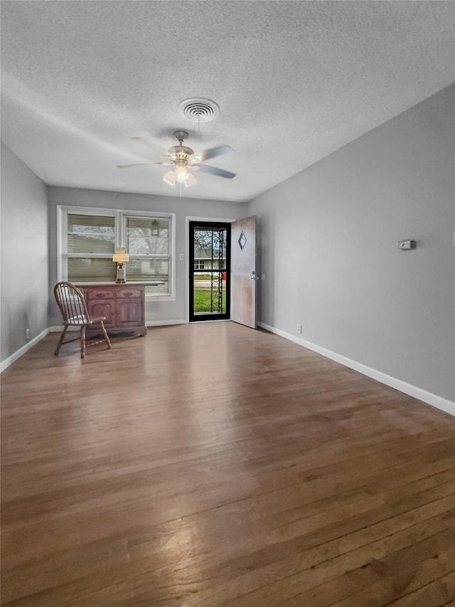 unfurnished room featuring dark hardwood / wood-style floors, a textured ceiling, and ceiling fan