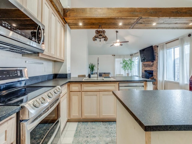 kitchen featuring sink, ceiling fan, stainless steel appliances, light tile patterned flooring, and a brick fireplace