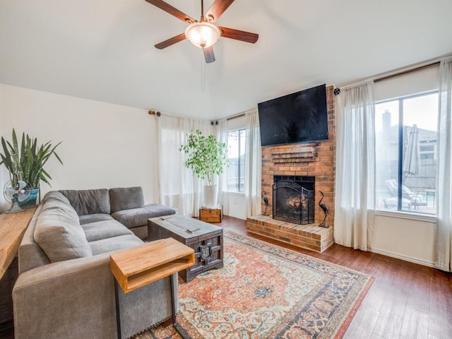 living room featuring a fireplace, wood-type flooring, and ceiling fan