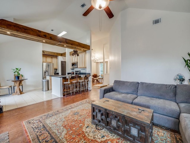 living room featuring vaulted ceiling with beams, ceiling fan, and light wood-type flooring