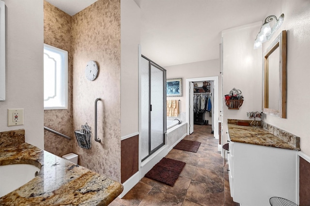 206 Pueblo Dr E, Lake Kiowa, TX 76240 - bathroom featuring a walk in closet, stone finish flooring, a stall shower, vanity, and baseboards