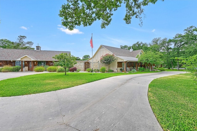 206 Pueblo Dr E, Lake Kiowa, TX 76240 - ranch-style house with board and batten siding, curved driveway, stone siding, and a front lawn