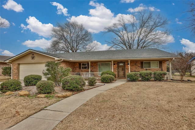 single story home featuring a porch, a garage, and a front yard