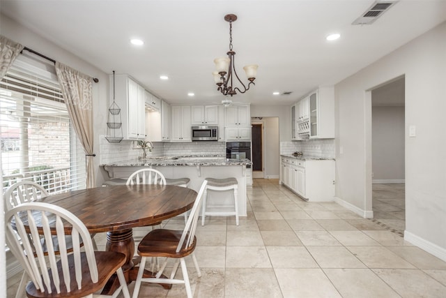 tiled dining area featuring sink and a notable chandelier