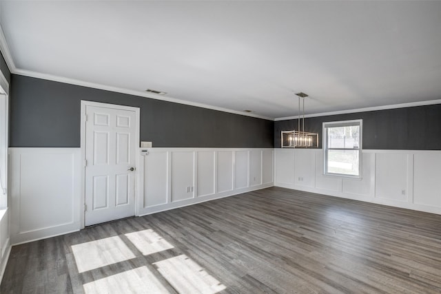 unfurnished dining area featuring hardwood / wood-style floors, a notable chandelier, and ornamental molding