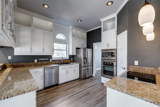 kitchen featuring stainless steel appliances, sink, pendant lighting, and white cabinets