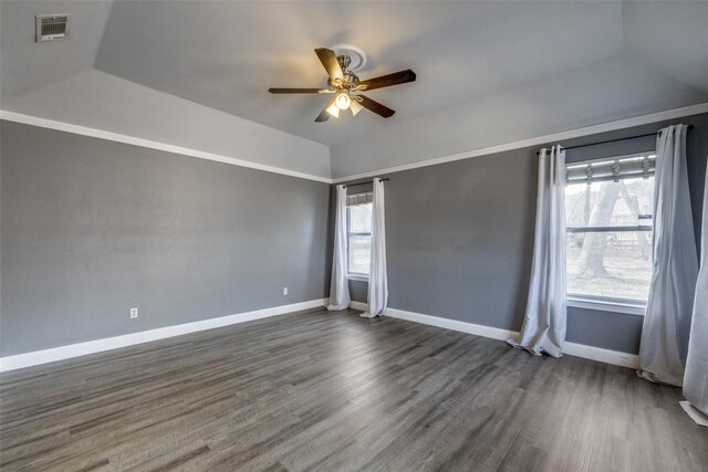 unfurnished room with dark wood-type flooring, ceiling fan, a raised ceiling, and vaulted ceiling